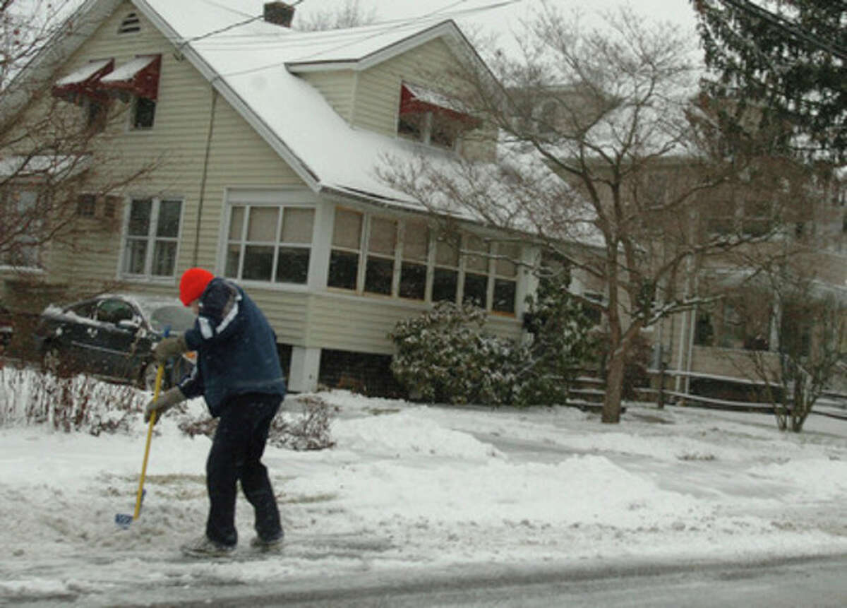 A man shovels the sidewalk on Gregory Boulevard in Norwalk during the snow storm Wednesday afternoon. Hour Photo / DANIELLE ROBINSON