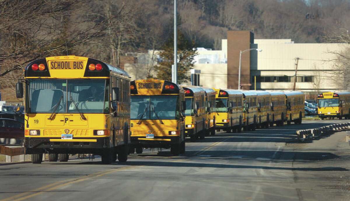 School buses travel down Kristine Lilly Way from Wilton High School to pick up students at Cider Mill on Thursday afternoon