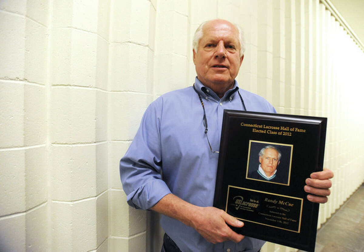 Hour photo/John Nash Former Norwalk High boys lacrosse coach Randy McCue holds the plaque he received in November upon his induction into the Connecticut Lacrosse Hall of Fame.