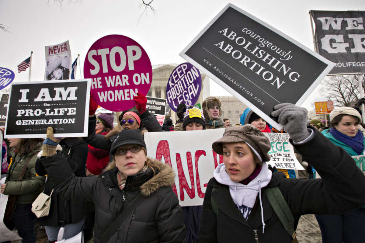 Anti-abortion activists and supporters of legal abortion stand in front of the Supreme Court in Washington, Friday, Jan. 25, 2013, on the 40th anniversary of the Roe v. Wade decision. Thousands of anti-abortion demonstrators marched through Washington to the steps of the U.S. Supreme Court to protest the landmark decision that legalized abortion. (AP Photo/J. Scott Applewhite)