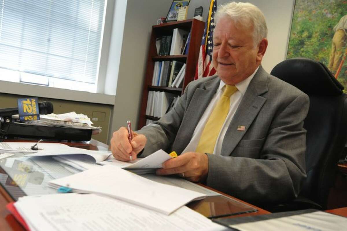 Norwalk Mayor Richard Moccia signs contracts for flooding work to be done in Norwalk. hour photo/matthew vinci