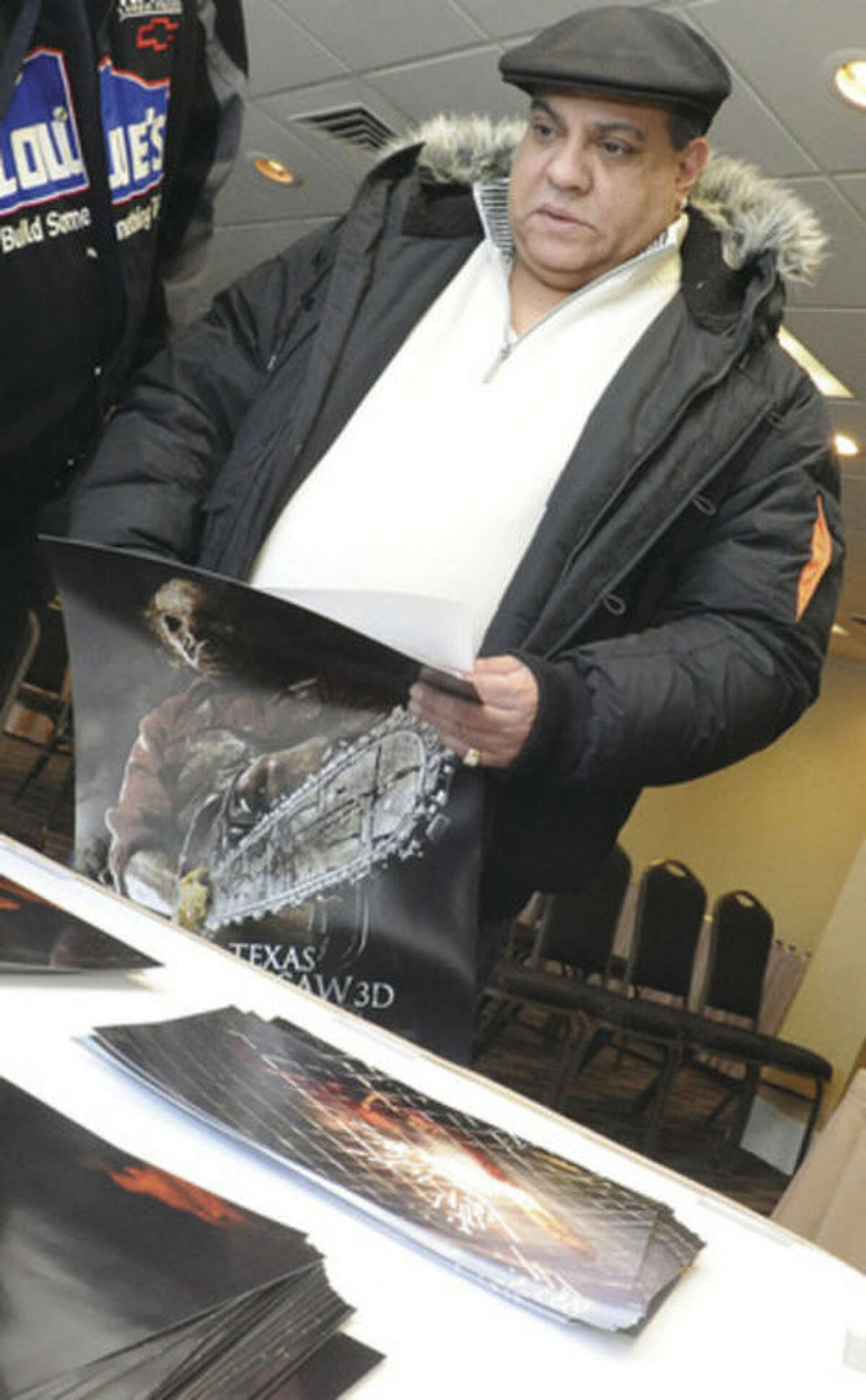 Eddie Rivera picks out a poster to get signed by actor Dan Yeager who plays Leatherface in the Texas Chainsaw films on Sunday at the Doubletree hotel in Norwalk. hour photo/Matthew Vinci