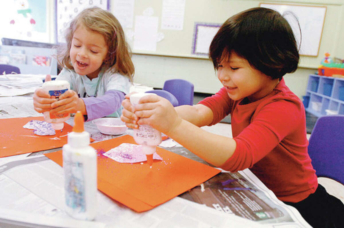 2 year olds in Wilton Parks and Recs' On School Road program, Gabby Coviello and Sofia Lugo, create art projects as part of preschool's daily activities. Hour photo / Erik Trautmann