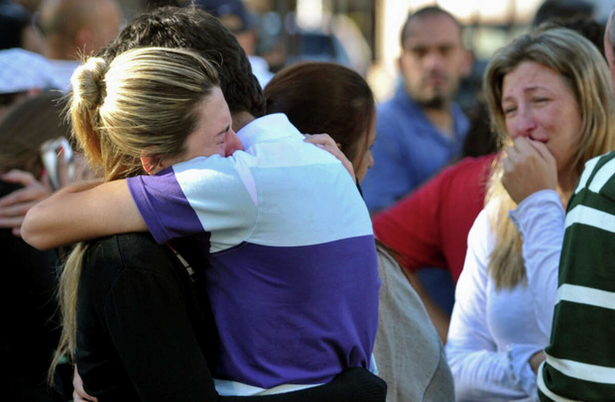 Relatives of victims react near the Kiss nightclub in Santa Maria city, Rio Grande do Sul state, Brazil, Sunday, Jan. 27, 2013. According to police more than 200 died in the devastating nightclub fire in southern Brazil. Officials say the fire broke out at the club while a band was performing. (AP Photo/Ronald Mendes-Agencia RBS)
