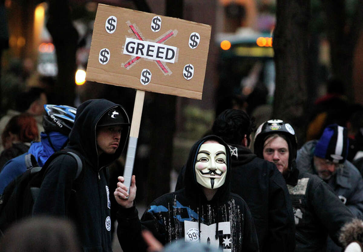 In this photo taken Wednesday, Nov. 2, 2011, an Occupy Seattle protester wears a Guy Fawkes mask while protesting in downtown Seattle. From New York to San Francisco to London, some of the demonstrators decrying a variety of society's ills are sporting the stylized masks loosely modeled on a 17th-century English terrorist, whether they know it or not. The masks come from "V for Vendetta," a comic-based movie whose violent, anarchist antihero fashions himself as a modern Guy Fawkes, the Catholic insurrectionist executed four centuries ago for trying to blow up Parliament. (AP Photo/Elaine Thompson)