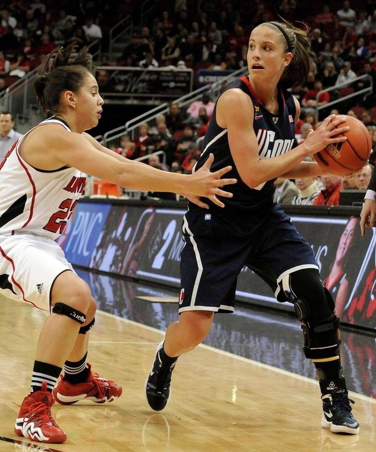 Connecticut's Caroline Doty, right, looks for an opening around Louisville's Shoni Schimmel during the second half of their NCAA college basketball game Tuesday, Feb. 7, 2012 in Louisville, Ky. Connecticut defeated Louisville 56-46. (AP Photo/Timothy D. Easley)