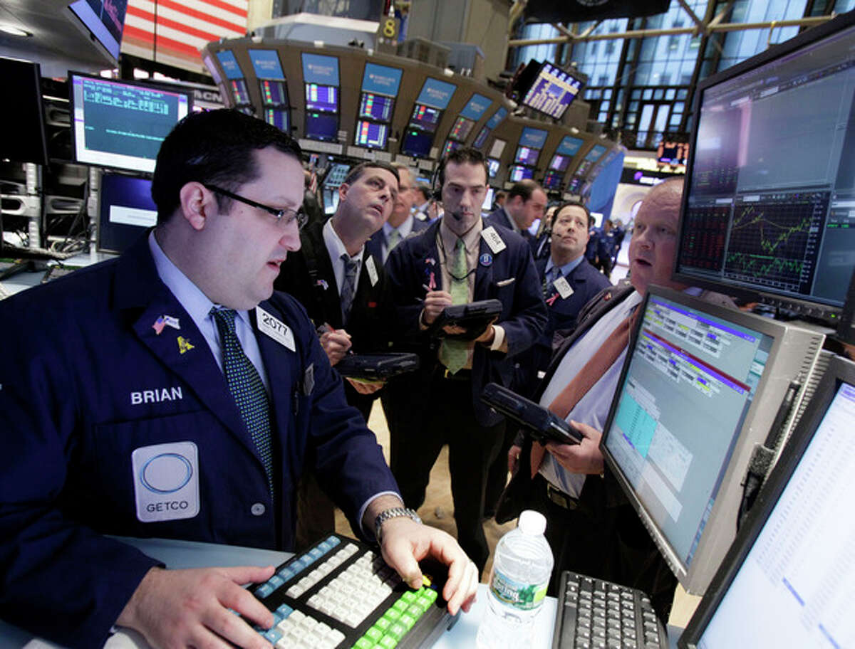 Traders gather at the post of specialist Brian Fairbrother, left, on the floor of the New York Stock Exchange Monday, Feb. 27, 2012. U.S. stocks pulled back Monday from some of their highest levels in three and a half years. (AP Photo/Richard Drew)