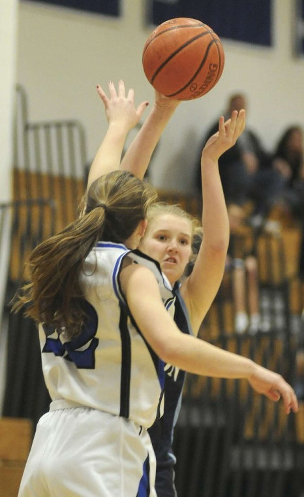 Hour photo/John Nash Wilton's Erin Cunningham, rear, looks to pass into the post as Darien's Susan Biggart defends during Tuesday's game.