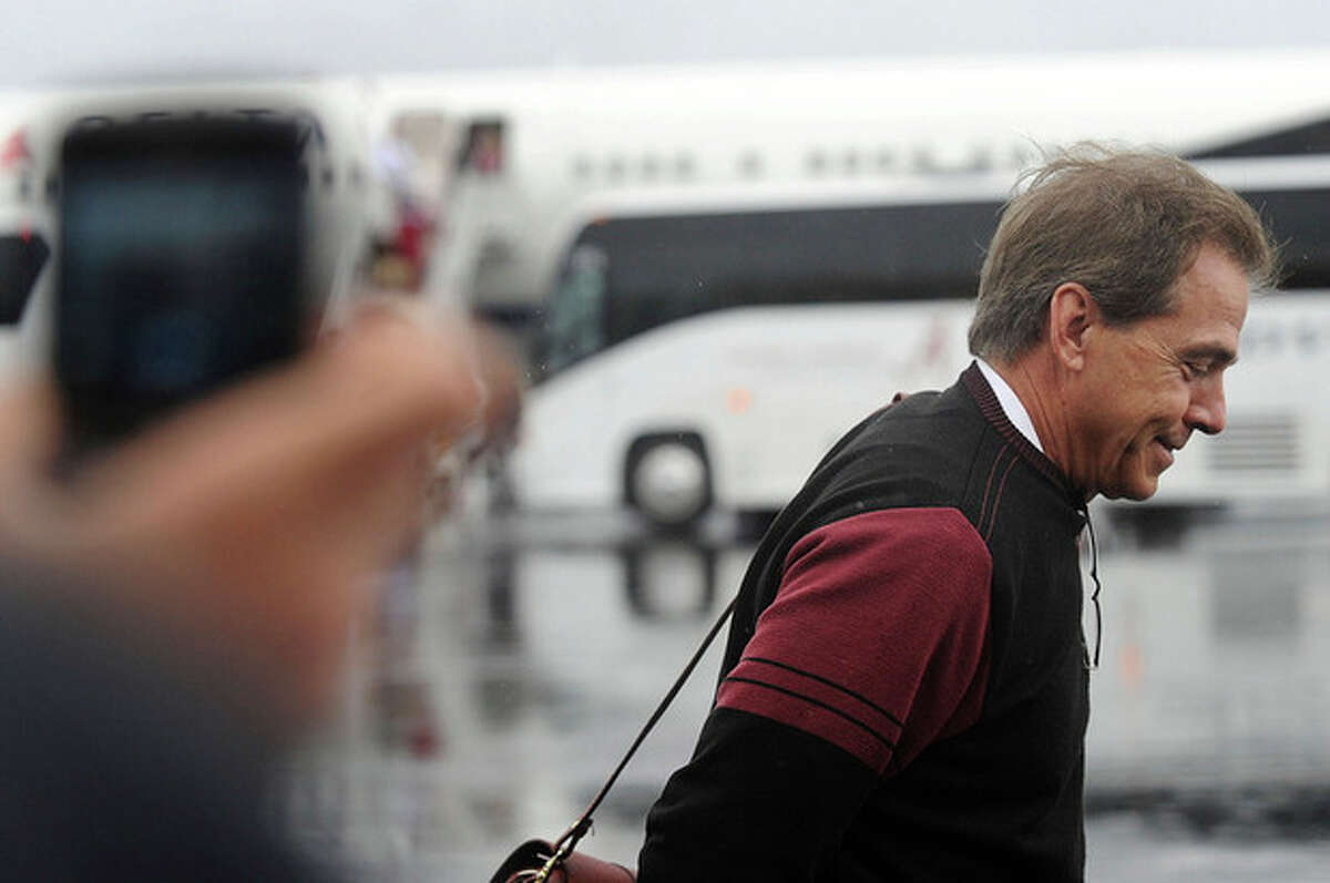 Coach Nick Saban smiles as he heads towards fans, at the Tuscaloosa Regional Airport, after he and the University of Alabama football team returned to Tuscaloosa, Ala., Tuesday, Jan. 10, 2012. Alabama defeated LSU 21-0 for the BCS National Championship title. It's the second national championship title in three years for Alabama. (AP Photo/The Birmingham News, Tamika Moore)