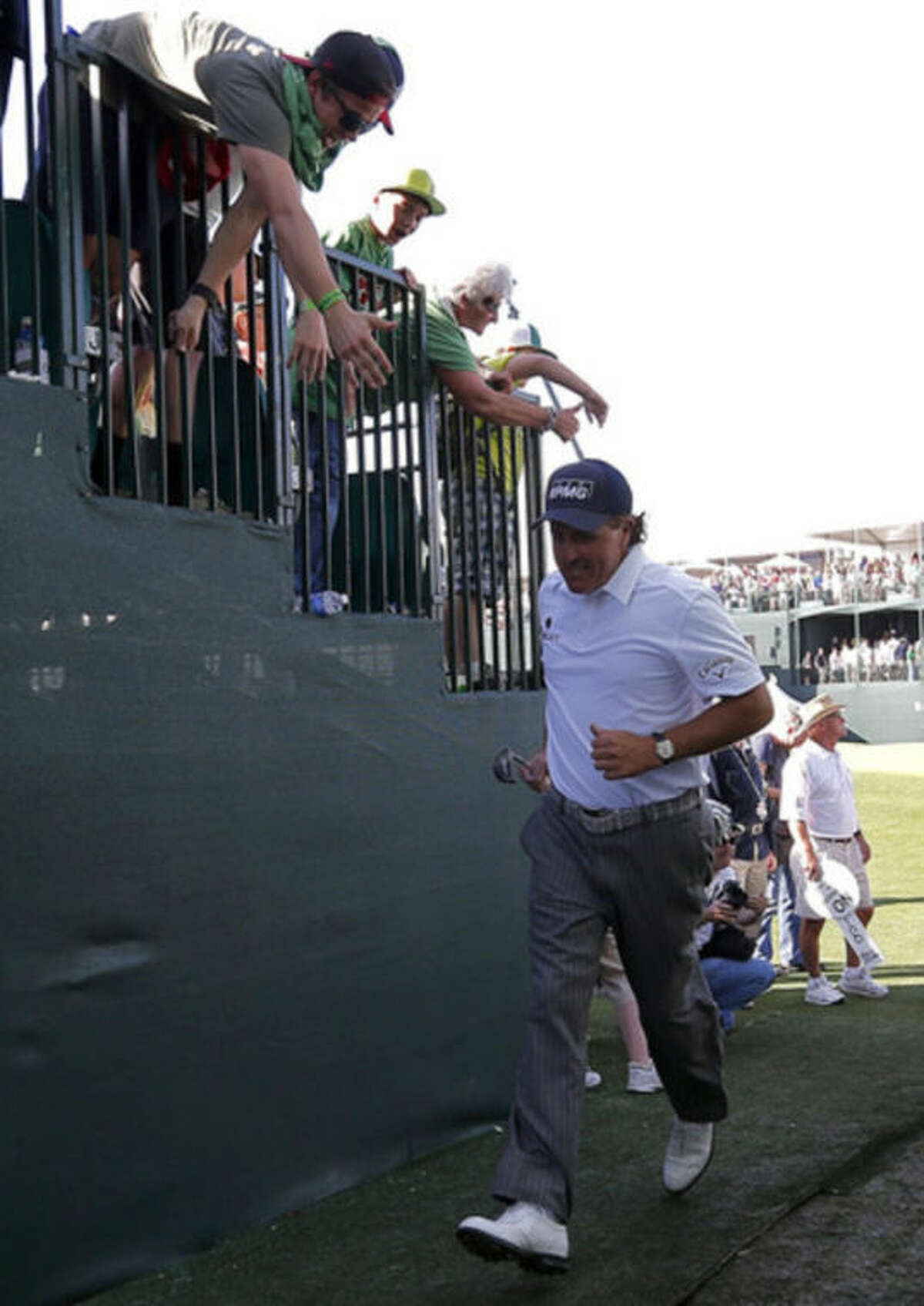 Phil Mickelson runs to the 17th tee from the 16th green during the third round of the Waste Management Phoenix Open golf tournament on Saturday, Feb. 2, 2013, in Scottsdale, Ariz. (AP Photo/Matt York)