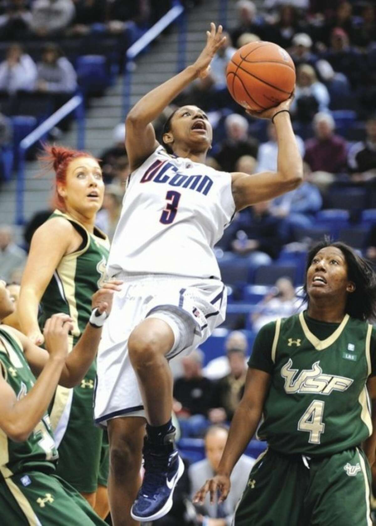 AP photo UConn's Tiffany Hayes shoots over a pair of South Florida defenders Saturday. Hayes had 33 points in the Huskies' 77-62 victory.