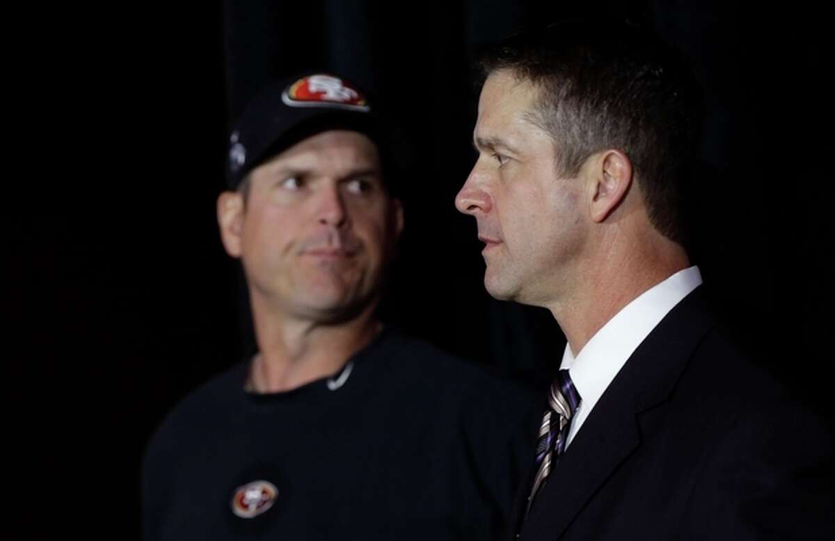 Brothers Jim Harbaugh, left, head coach for the San Francisco 49ers, and John Harbaugh, head coach for the Baltimore Ravens, arrive at a news conference for the upcoming Super Bowl XLVII in New Orleans, Friday, Feb. 1, 2013. (AP Photo/Gerald Herbert)