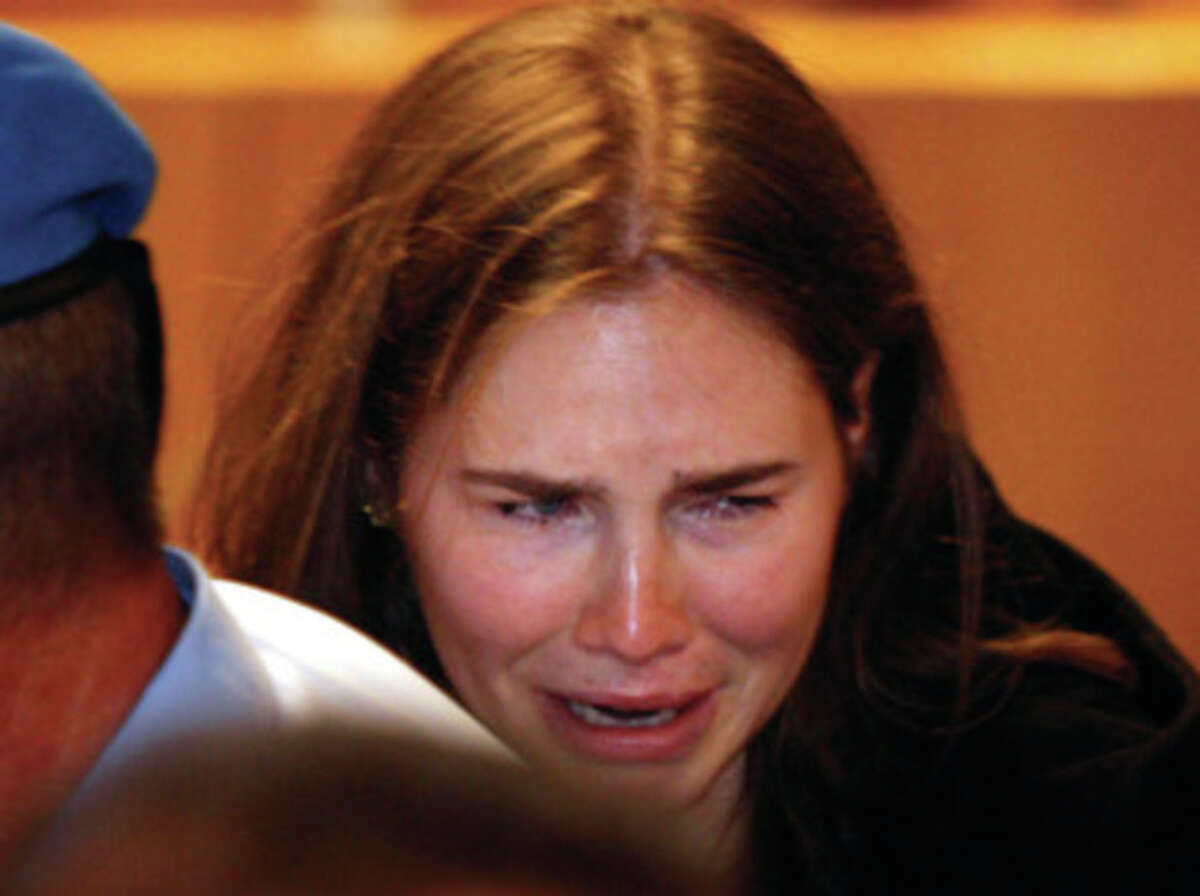Amanda Knox breaks in tears after hearing the verdict that overturns her conviction and acquits her of murdering her British roommate Meredith Kercher, at the Perugia court, central Italy, Monday, Oct. 3, 2011. Italian appeals court threw out Amanda Knox's murder conviction Monday and ordered the young American freed after nearly four years in prison for the death of her British roommate Knox collapsed in tears after the verdict overturning her 2009 conviction was read out. Her co-defendant, Italian Raffaele Sollecito, also was cleared of killing 21-year-old Meredith Kercher in 2007. (AP Photo/Pier Paolo Cito)