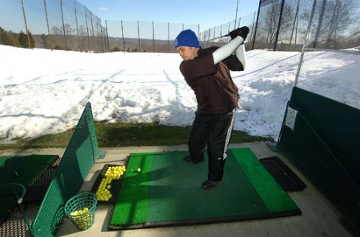 Photo/Alex von Kleydorff. Dan Buoncontri takes a swing at the Sterling Farms Golf Course Driving Range. There is always time to work on your game he says, using yellow colored balls in the snow helps the range staff find and collect them by hand one by one.