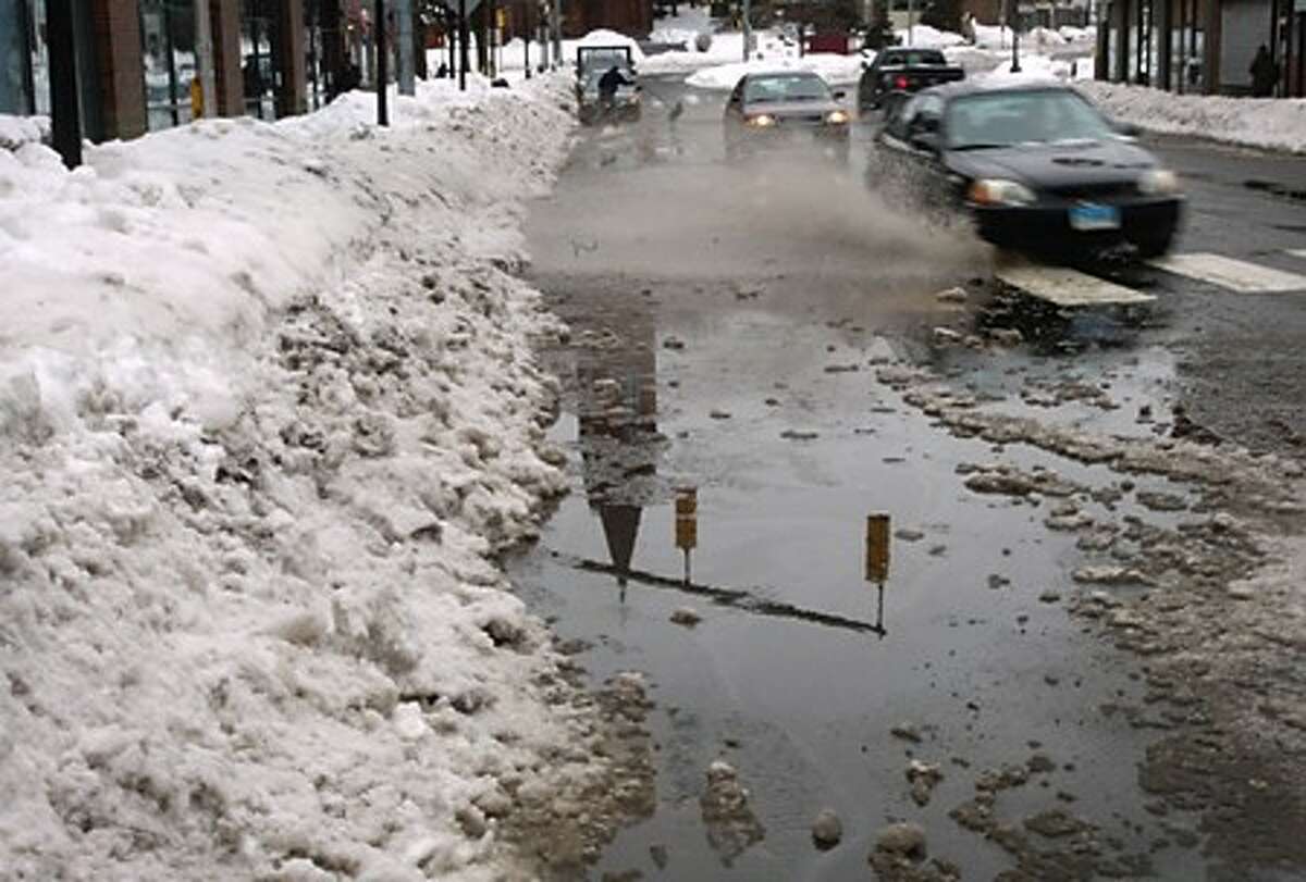 Storm drains blocked by snow and ice cause flooding on North Main St in Norwalk Wednesday. Hour photo / Erik Trautmann
