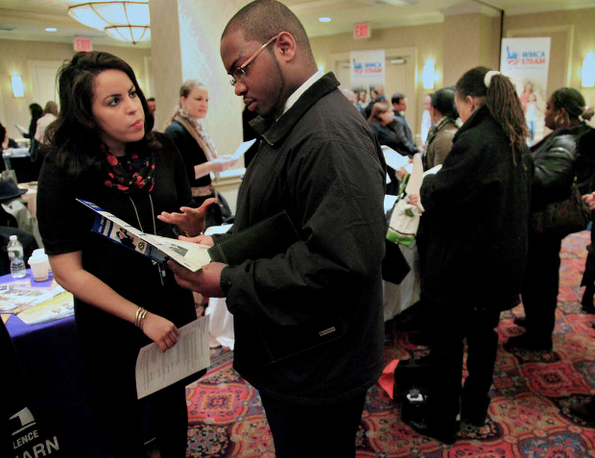 In this Jan. 25, 2012 photo, Daniela Silvero,left, an admissions officer at ASA College, discuss job opportunities with Patrick Rosarie, who is seeking a job in IT, during JobEXPO's job fair, in New York. The unemployment rate fell for the fifth straight month after a surge of January hiring, a promising shift in the nation's outlook for job growth. (AP Photo/Bebeto Matthews)