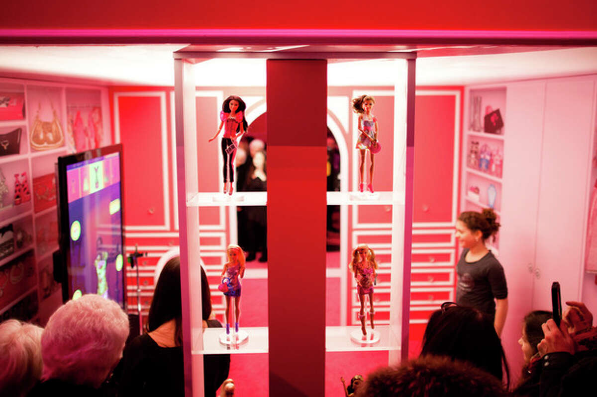 Barbie dolls stand on shelves at the Barbie Dream House party during Fashion Week in New York, Friday, Feb. 10, 2012. (AP Photo/John Minchillo)