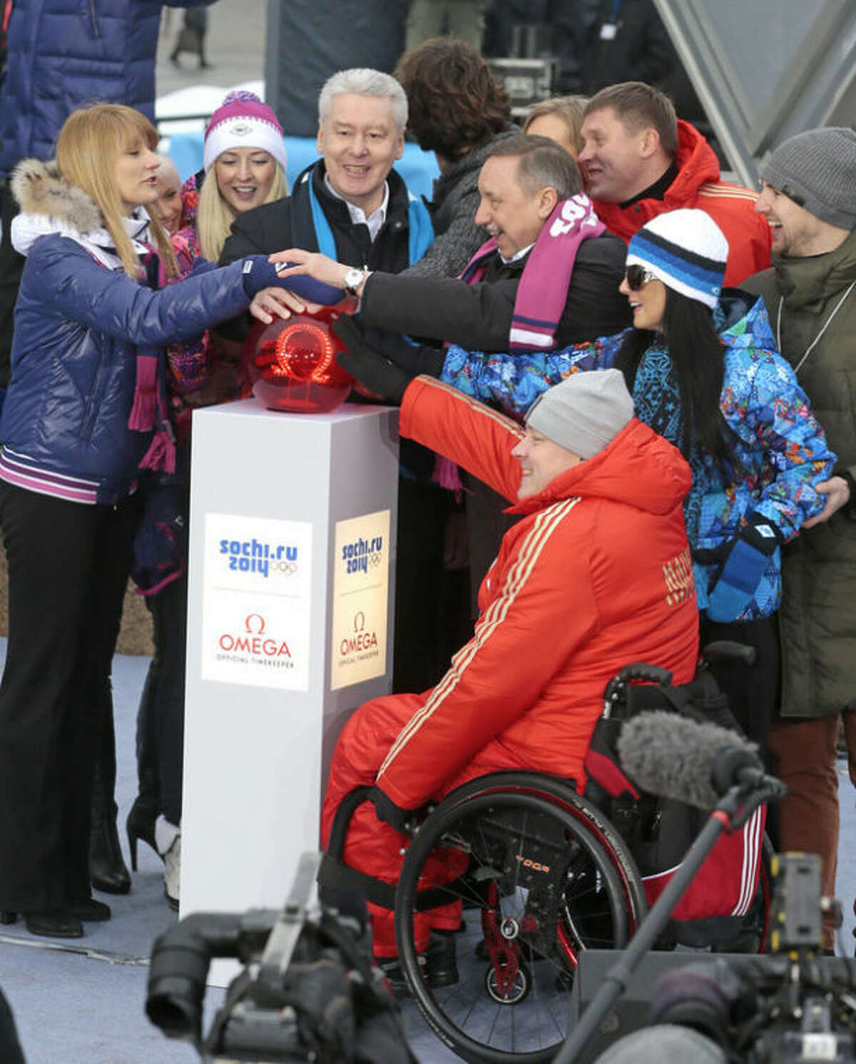 Moscow's Mayor Sergei Sobyanin, center, surrounded by various sport enthusiasts and entertainers hits a symbolic button to launch the one-year count down clock for the upcoming 2014 Sochi Olympics in Moscow, Russia, Thursday, Feb. 7, 2013. (AP Photo/Mikhail Metzel)
