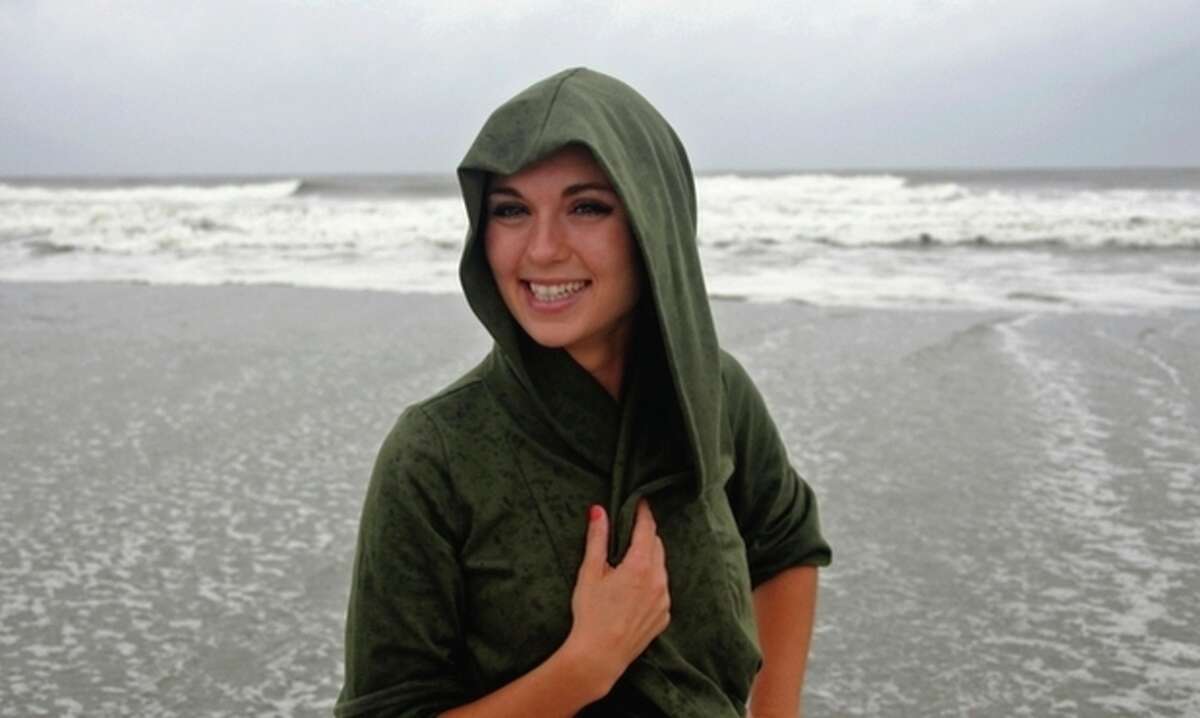 Sarah Rich of Greensboro, N.C. holds her hoddie as rain blows while she walks along the oceanfront in North Myrtle Beach, S.C. looking at the waves created as Hurricane Irene begins to approach the area, Friday, Aug. 26, 2011. (AP Photo/The Sun News, Charles Slate)