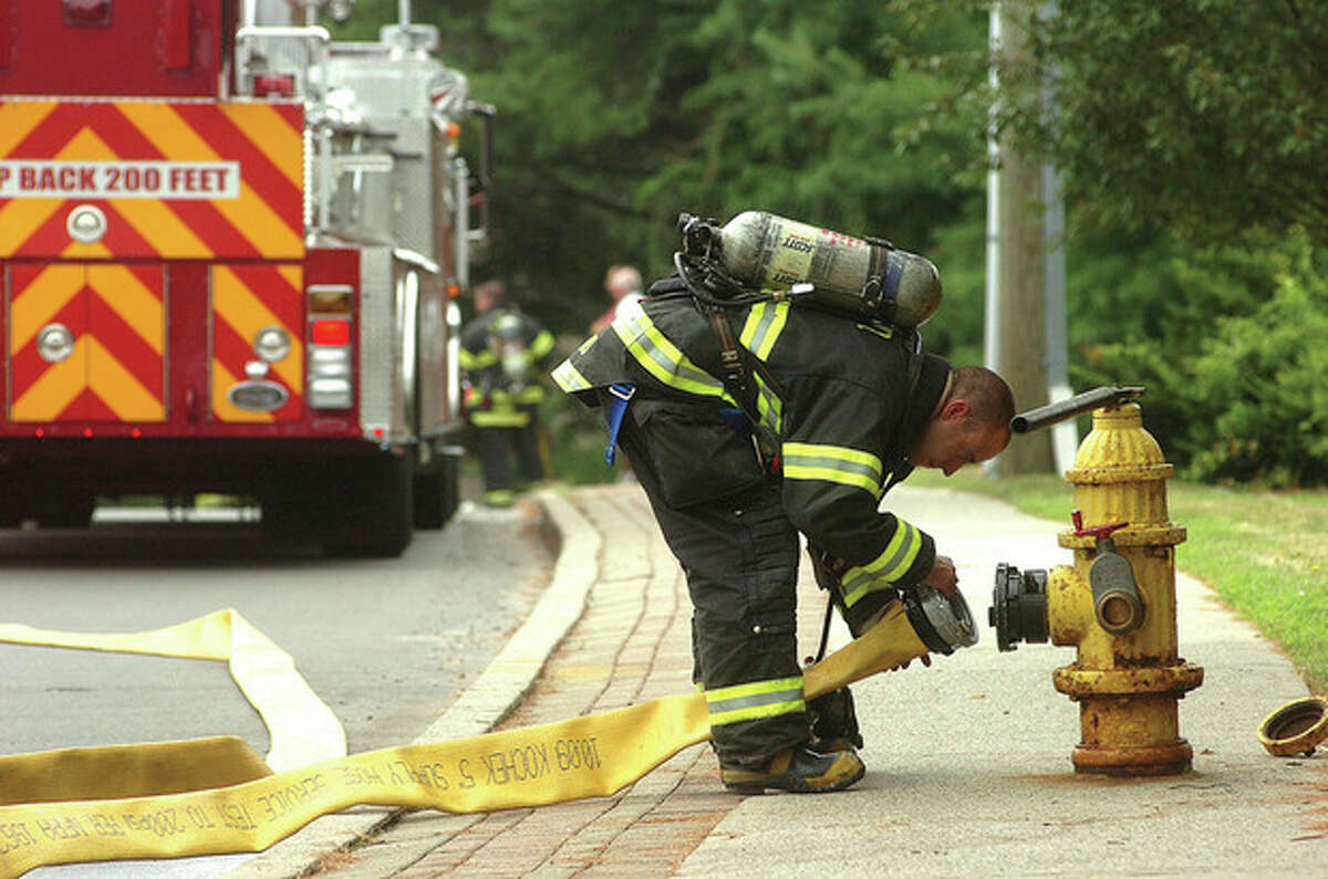 Hour Photo/Alex von Kleydorff. Norwalk Firefighters prepare hoses as they respond to a gas leak on Richards Ave.
