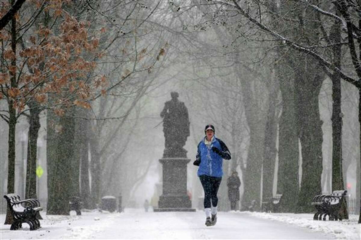 A runner runs in the snow in the park along Commonwealth Ave in Boston, Friday, Feb. 8, 2013. Snow began falling across the Northeast on Friday, ushering in what was predicted to be a huge, possibly historic blizzard and sending residents scurrying to stock up on food and gas up their cars. The storm could dump 1 to 3 feet of snow from New York City to Boston and beyond. (AP Photo/Gene J. Puskar)