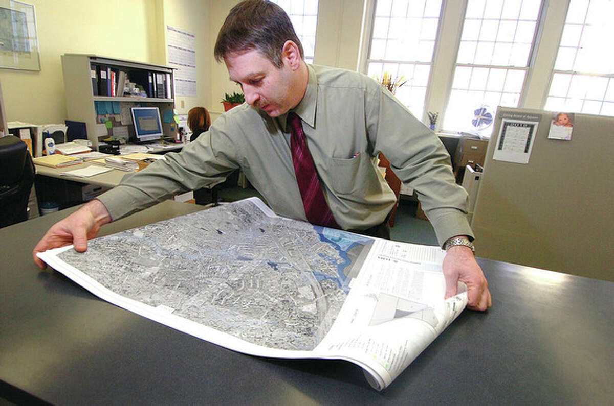 Hour photo / Alex von Kleydorff Town of Westport's Director of Planning and Zoning Laurence Bradley unfolds seven new FEMA flood maps for the town.