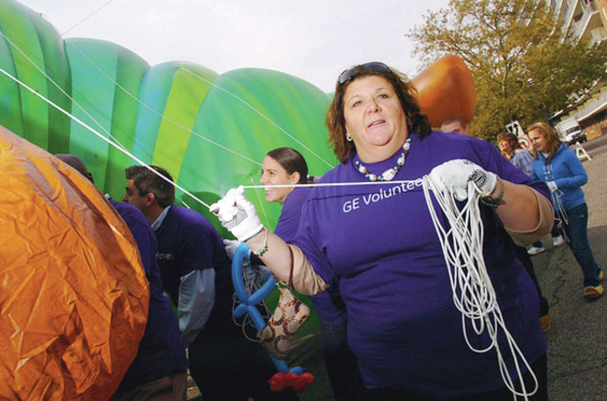 Volunteer balloon handler, Danette Melchionne of GE, trains for the Thanksgiving parade during a press conference Thursday at Latham Park in Stamford. The volunteer balloon handlers, representatives from Stamford Downtown Special Services and Title Sponsor, UBS, gathered under the brand new 35-foot long "The Very Hungry Caterpillar" balloon to announce details of the parade on Sunday the 20th. Hour photo / Erik Trautmann