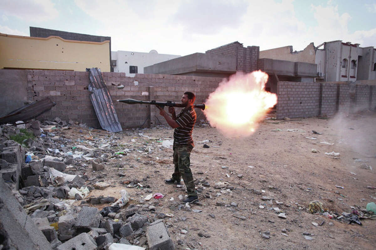 A revolutionary fighter fires a rocket-propelled grenade at Gadhafi loyalists in downtown Sirte, Libya, Tuesday, Oct. 18, 2011. About 1,000 Libyan revolutionary troops have launched a major assault on Moammar Gadhafi's hometown, surging from the east to try to capture the last area under loyalist control. (AP Photo/Manu Brabo)