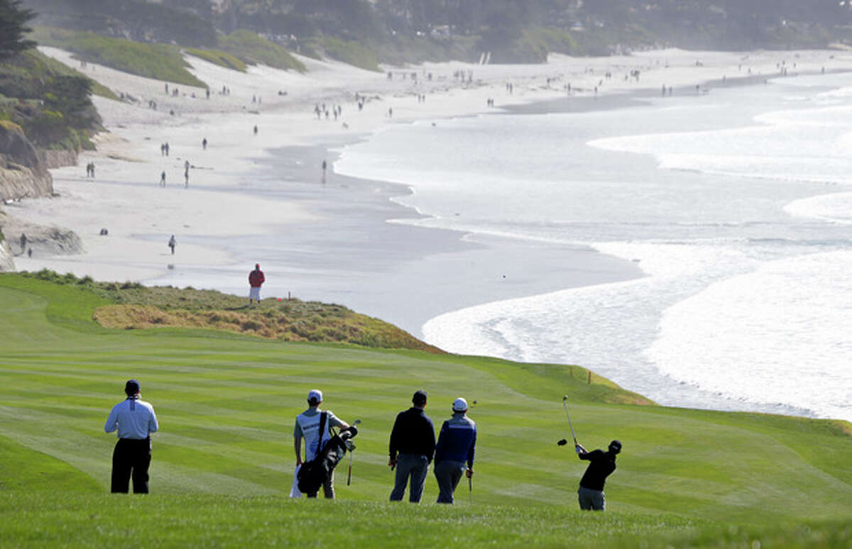 Patrick Cantlay, right, hits from the fairway down to the ninth green of the Pebble Beach Golf Links during the third round of the AT&T Pebble Beach Pro-Am golf tournament Saturday, Feb. 9, 2013, in Pebble Beach, Calif. (AP Photo/Eric Risberg)