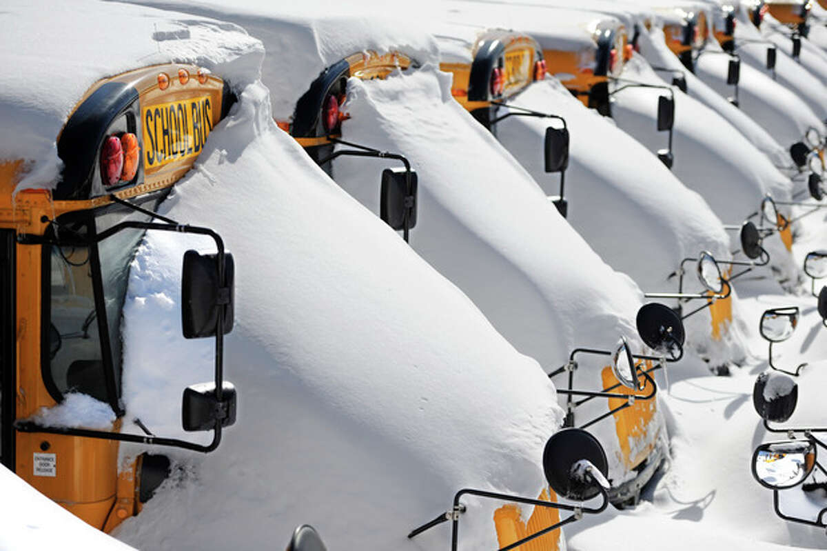 School buses are covered in snow after a winter storm in Hartford, Conn., Sunday, Feb. 10, 2013. A howling storm across the Northeast left much of the New York-to-Boston corridor covered with more than three feet of snow on Friday into Saturday morning. (AP Photo/Jessica Hill)