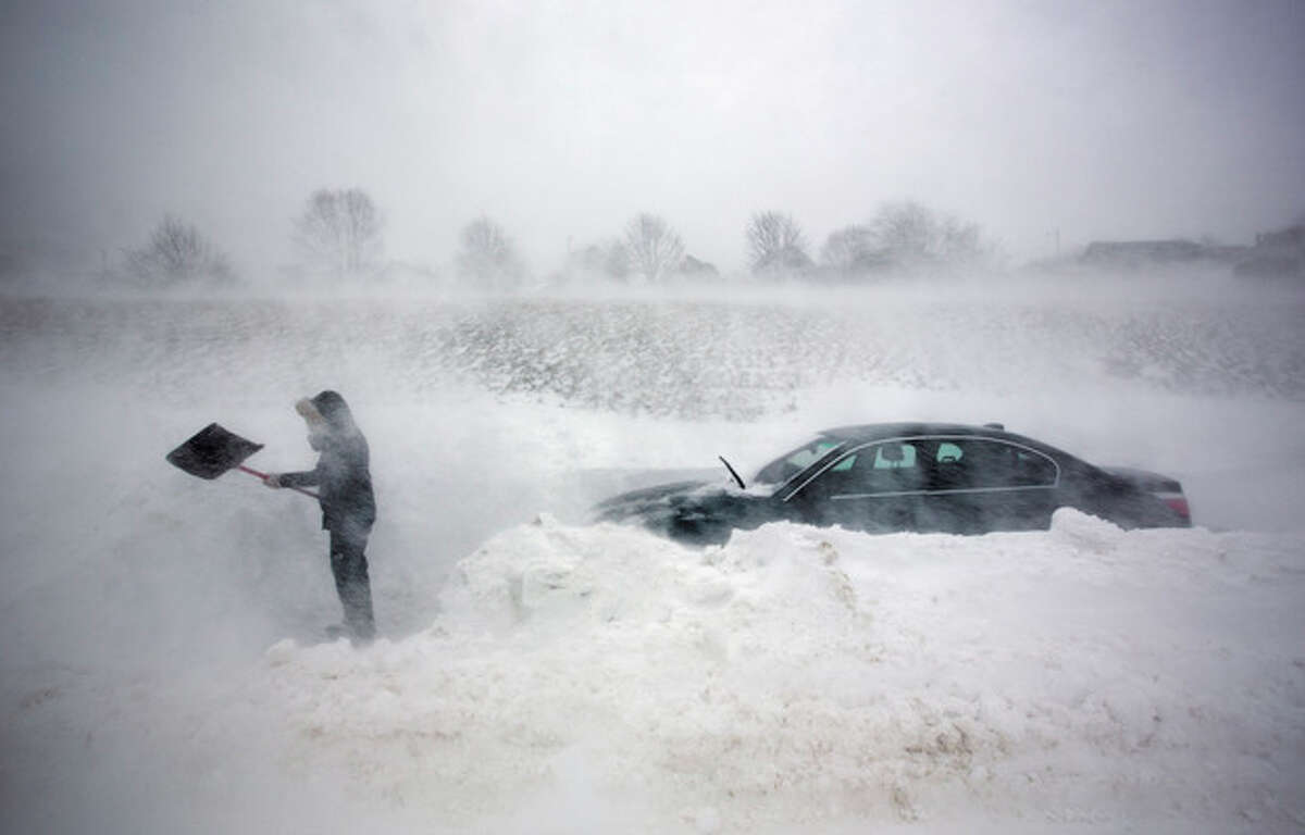 A woman digs out her car after it was blocked in by drifting snow during a blizzard, Saturday, Feb. 9, 2013, in Portland, Maine. The storm dumped more than 30 inches of snow as of Saturday afternoon, breaking the record for the biggest storm on record. (AP Photo/Robert F. Bukaty)