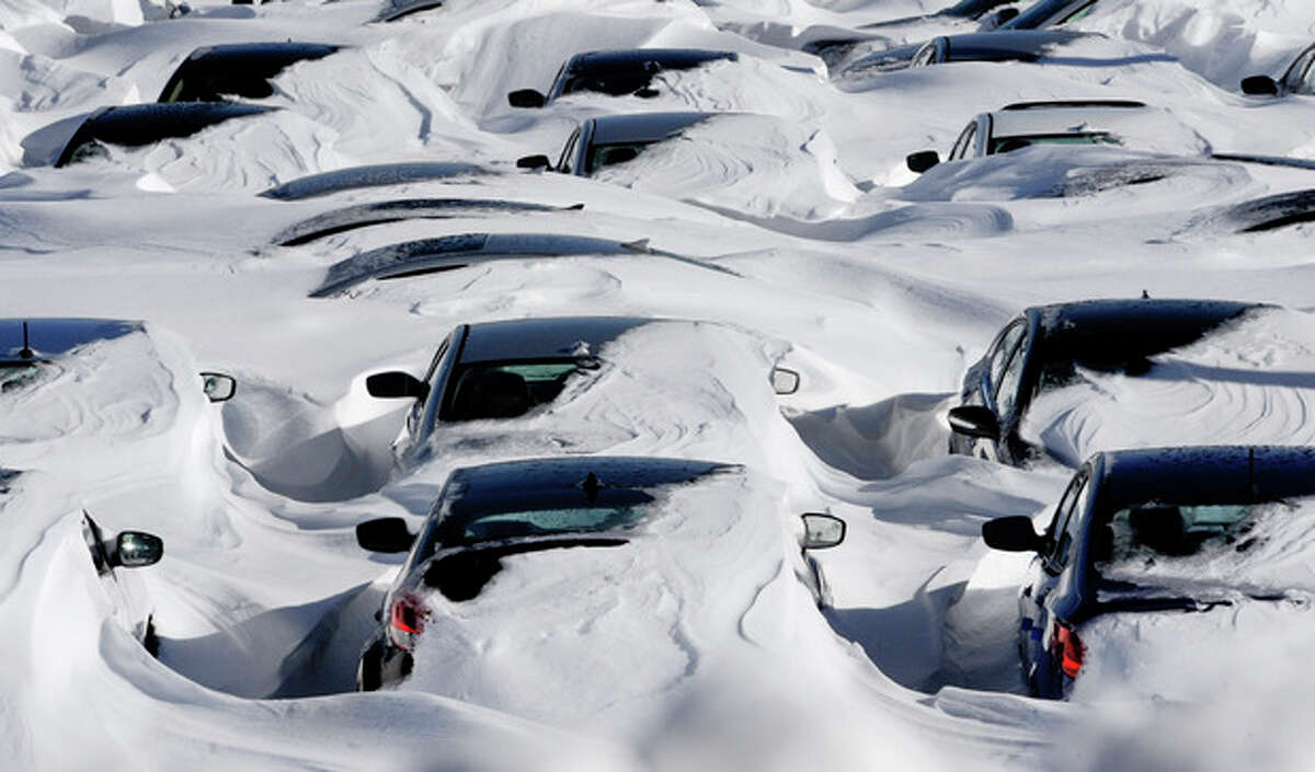 Snow begins to melt on cars parked at a dealership after a winter storm in Hartford, Conn., Sunday, Feb. 10, 2013. A howling storm across the Northeast left much of the New York-to-Boston corridor covered with more than three feet of snow on Friday into Saturday morning. (AP Photo/Jessica Hill)
