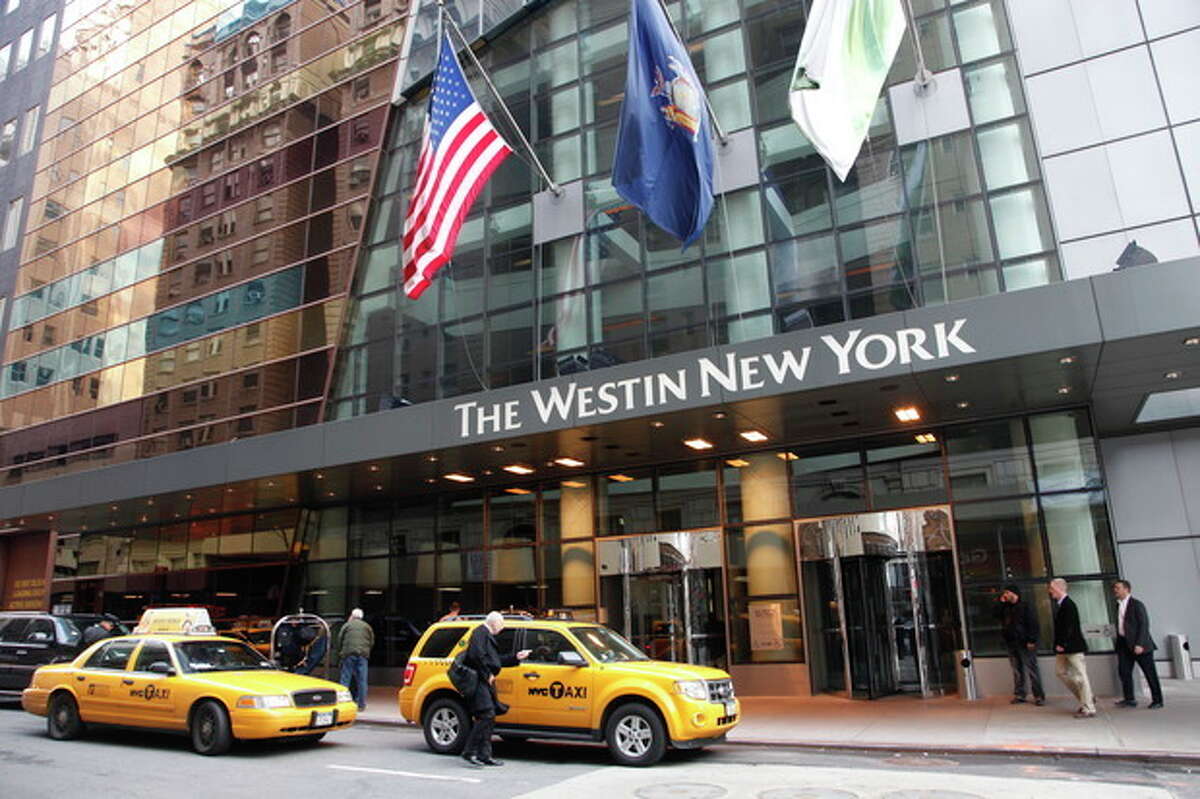 A man hails a taxi in front of the Westin New York hotel, Wednesday, Feb. 1, 2012 in New York. Starwood Hotels & Resorts Worldwide Inc. said Thursady, Feb. 2, its fourth-quarter net income dropped 51 percent on impairment charges and other items, but its performance beat analysts' expectations. (AP Photo/Mark Lennihan)