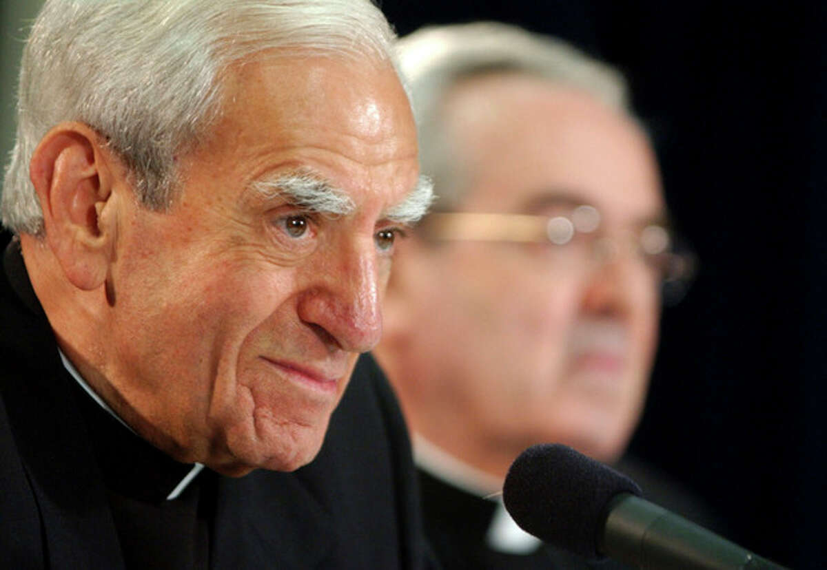 FILE - In this July 15, 2003 file photo, Cardinal Anthony J. Bevilacqua listens to a reporter's question as St. Louis Archbishop Justin F. Rigali, right, listens at a news conference in Philadelphia. The child-molestation scandal in the Archdiocese of Philadelphia has taken a mysterious new turn, with prosecutors asking a coroner to examine the body of Cardinal Anthony Bevilacqua to establish whether he died of natural causes, Friday, Feb. 10, 2012. (AP Photo/Jacqueline Larma, File)