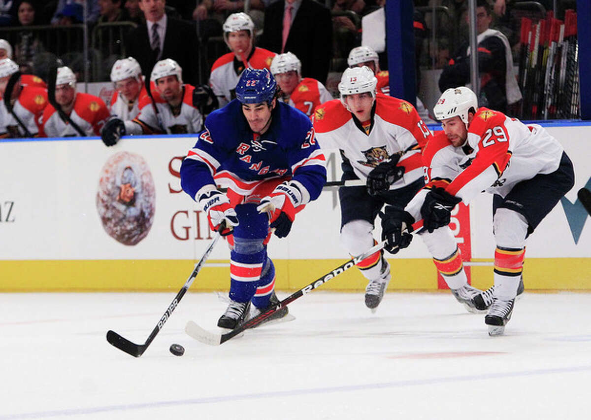 New York Rangers' Brian Boyle (22) and Florida Panthers' Bill Thomas (29) fight for control of the puck as Panthers' Mike Santorelli, center, trails the play during the second period of an NHL hockey game Thursday, Jan. 5, 2012, in New York. (AP Photo/Frank Franklin II)