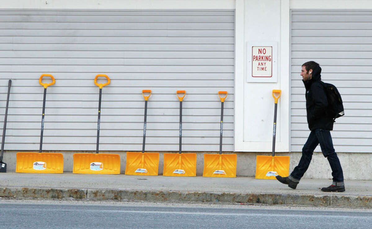 A man walks by a line of snow shovels for sale at a Reny's store, Thursday, Jan. 5, 2012, in Bridgton, Maine. Across much of the Northeast most natural snow has either melted or been washed away by rain. (AP Photo/Robert F. Bukaty)