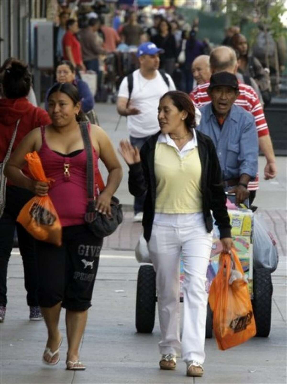 Latinos and others are seen on Broadway in downtown Los Angeles, where many businesses cater to a Spanish-speaking clientele, Wednesday, May 11, 2011. According to Census Bureau figures to be released Thursday, May 12, the population of people of Mexican descent in California grew by 6 percent in the last decade, and represent 31 percent of the total in the state. (AP Photo/Reed Saxon)