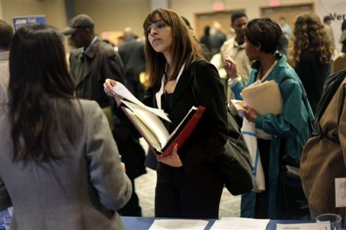 FILE - In this April 18, 2011 file photo, a woman at a job fair in New York talks to an employer. For the first time, American women have passed men in gaining advanced college degrees as well as bachelor''s degrees, part of a trend that is helping redefine who goes off to work and who stays home with the kids. (AP Photo/Seth Wenig, File)