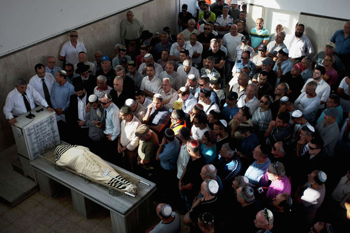Family and friends of Ami Moshe gather next to his body during his funeral procession in Ashkelon, southern Israel, Sunday, Oct. 30, 2011. Moshe was killed after a rocket fired by Palestinians militants from Gaza Strip hit the town of Ashkelon on Saturday night. On Saturday, nine militants and an Israeli civilian were killed in some of the worst violence in the area in months. (AP Photo/Ariel Schalit)
