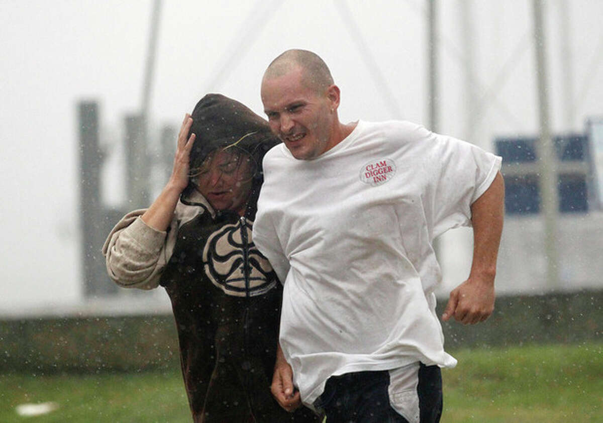 A man and a woman brace against wind and rain as Hurricane Irene approaches Saturday, Aug. 26, 2011 in Monteo, N.C. (AP Photo/John Bazemore)