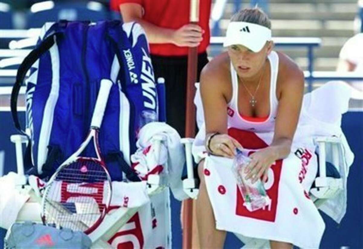 Caroline Wozniacki, of Denmark, rests during a break in her match against Roberta Vinci, of Italy, at the Rogers Cup tennis tournament in Toronto on Wednesday, Aug. 10, 2011. Vinci won 6-4, 7-5. (AP Photo/The Canadian Press, Darren Calabrese)