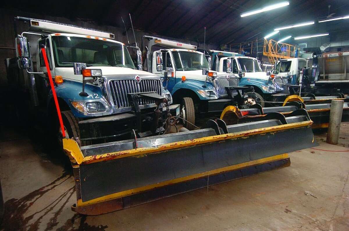 Hour Photo/ Alex von Kleydorff. Trucks with plows attached sit inside the DPW garage in Wilton.