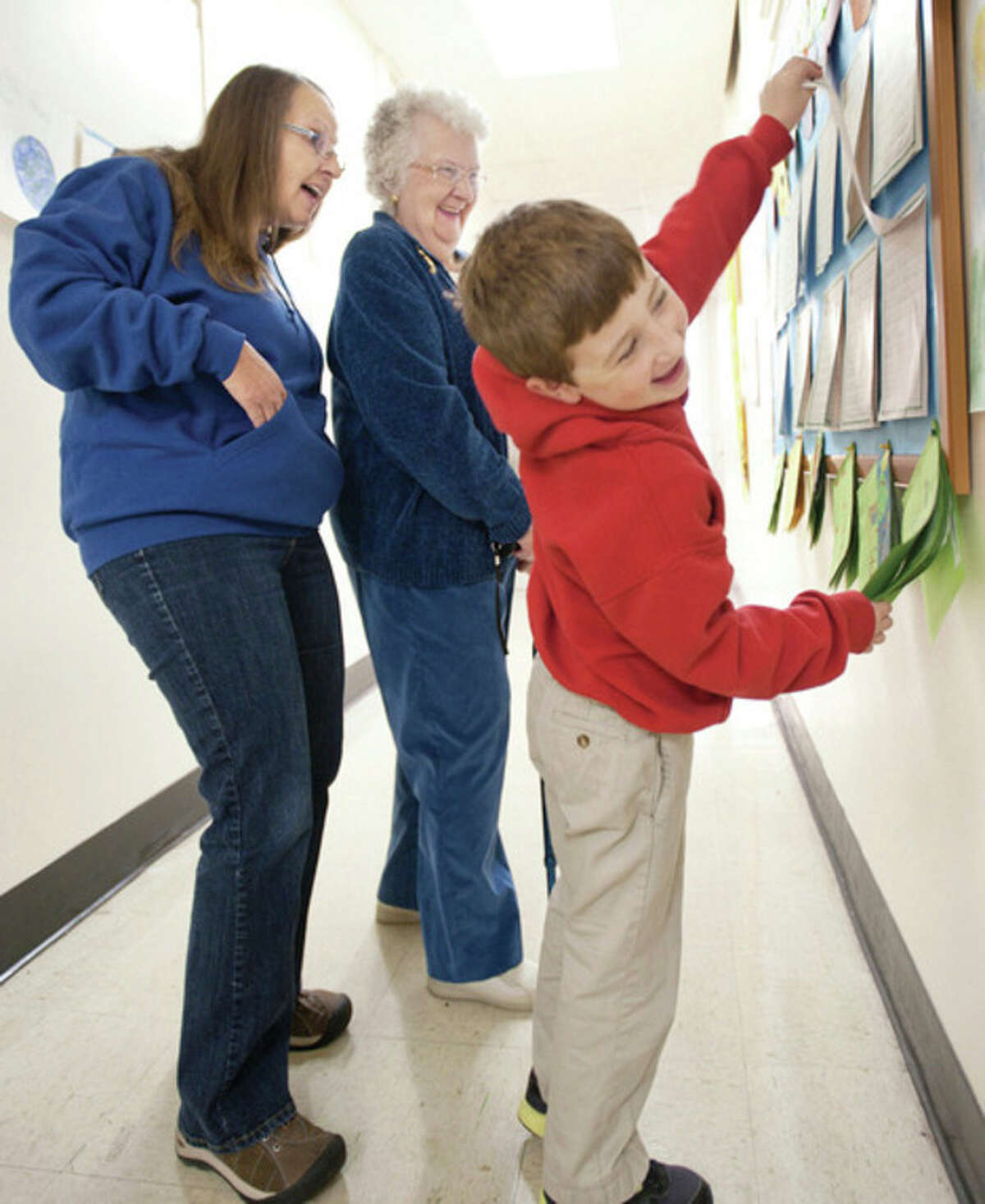AP photo / Sedalia Democrat, Sydney Brink Second-grader Edson Kehde, of Sedalia, Mo., holds up the first page of a story he wrote about himself Friday so that his grandmother, Carolyn Starke, left, and great-grandmother Sue Cromley can read the second page in a hallway at Sacred Heart School during the school's annual Grandparents Day.