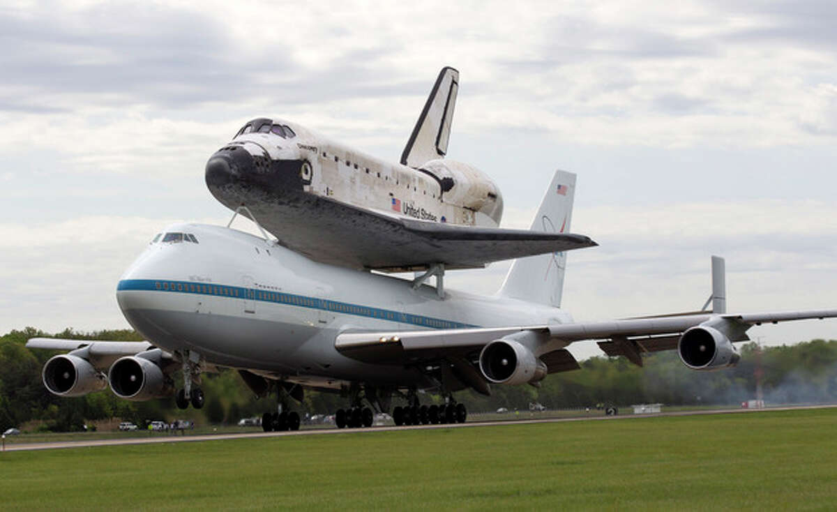 The space shuttle Discovery, sitting atop a 747 carrier aircraft, lands at Dulles International Airport in Chantilly, Va., Tuesday, April 17, 2012. Discovery, the longest-serving orbiter will be placed to its new home, the Smithsonian's National Air and Space Museum's Steven F. Udvar-Hazy Center in Chantilly, Va. (AP Photo/Manuel Balce Ceneta)