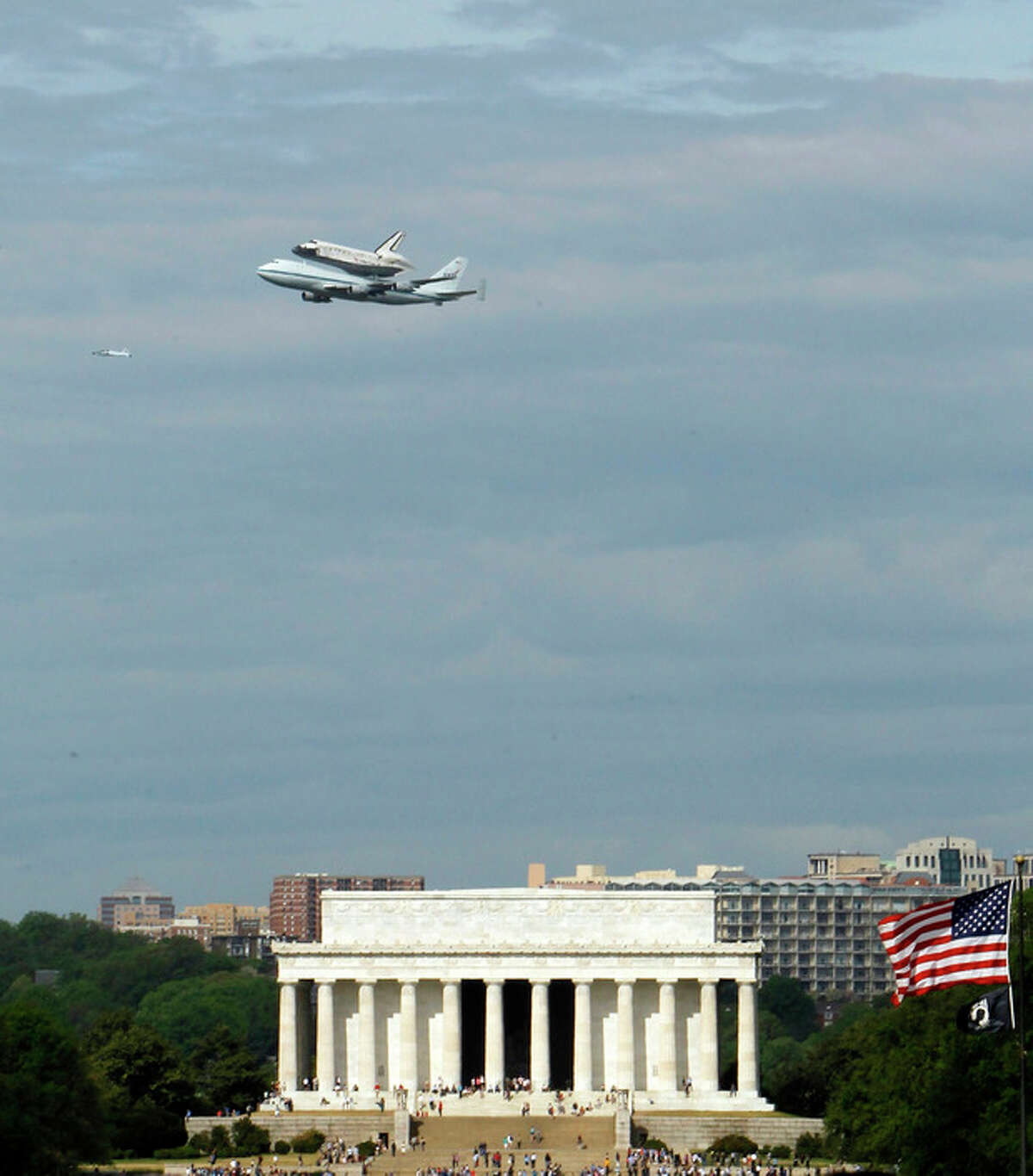 The Space Shuttle Discovery, mounted on the Shuttle Carrier Aircraft, flies over the Lincoln Memorial in Washington, Tuesday, April 17, 2012. Discovery is en route from Kennedy Space Center to the Smithsonian National Air and Space Museum Udvar/Hazy Center at Dulles International Airport. (AP Photo/Ann Heisenfelt)