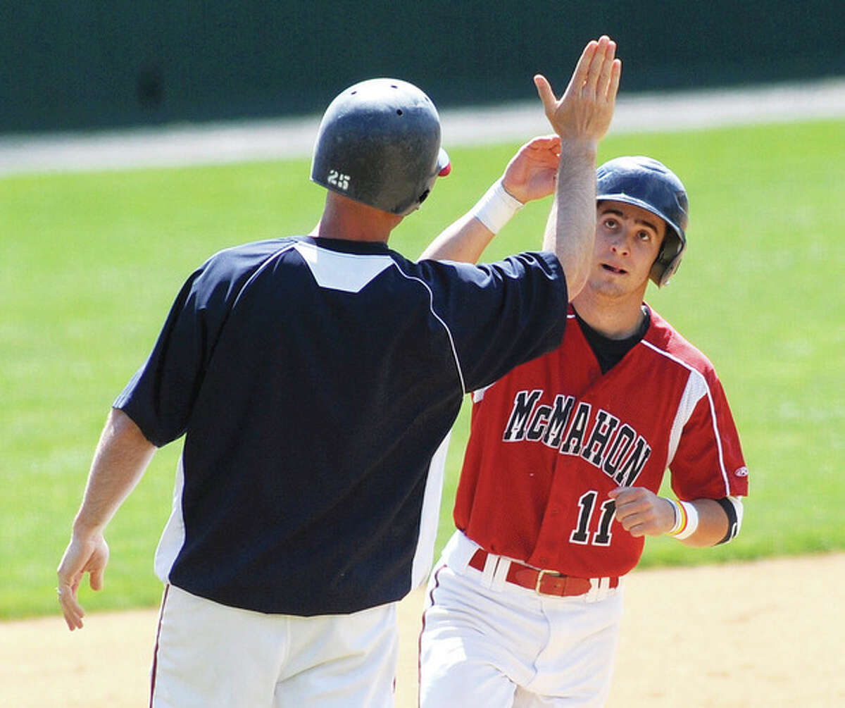 Hour photo/John Nash Brien McMahon's Bryan Daniello, right, gets a high five from head coach John Cross as he jogs around third base after Daniello hit a two-run home run in the first inning of Friday's FCIAC game against Fairfield Warde at Doubleday Field in Cooperstown, N.Y. McMahon shut out Warde, 9-0.,