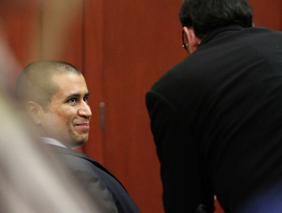 George Zimmerman smiles with a member of his defense team after he was granted bond, Friday, April 20, 2012, during a hearing in Sanford, Fla. Circuit Judge Kenneth Lester says Zimmerman can be released on $150,000 bail as he awaits trial for the shooting death of Trayvon Martin. Zimmerman is charged with second-degree murder in the shooting of Martin. He claims self-defense. (AP Photo/Orlando Sentinel, Gary W. Green, Pool)