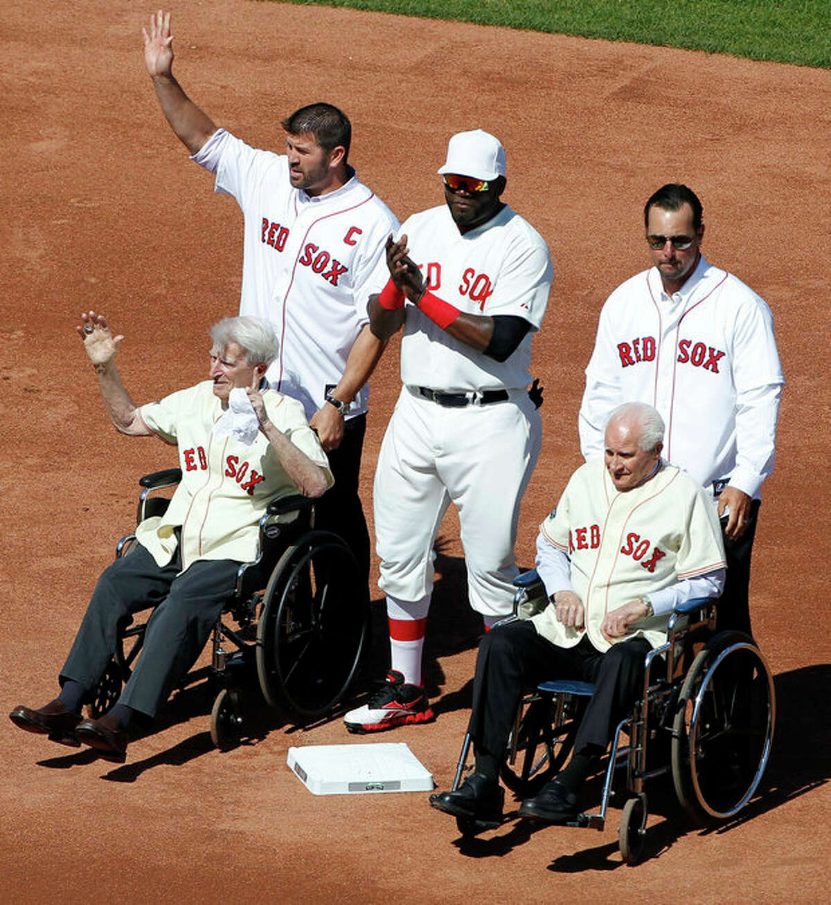 Former Boston Red Sox catcher Jason Varitek, top left, stands with, current designated hitter David Ortiz, top center, former pitcher Tim Wakefield, top right, and former players Bobby Doerr, seated right, and Johnny Pesky, seated left, on the field during ceremonies to celebrate the 100th anniversary of a regular season baseball game at Fenway Park before the game between the New York Yankees and the Red Sox in Boston, Friday, April 20, 2012. (AP Photo/Michael Dwyer)