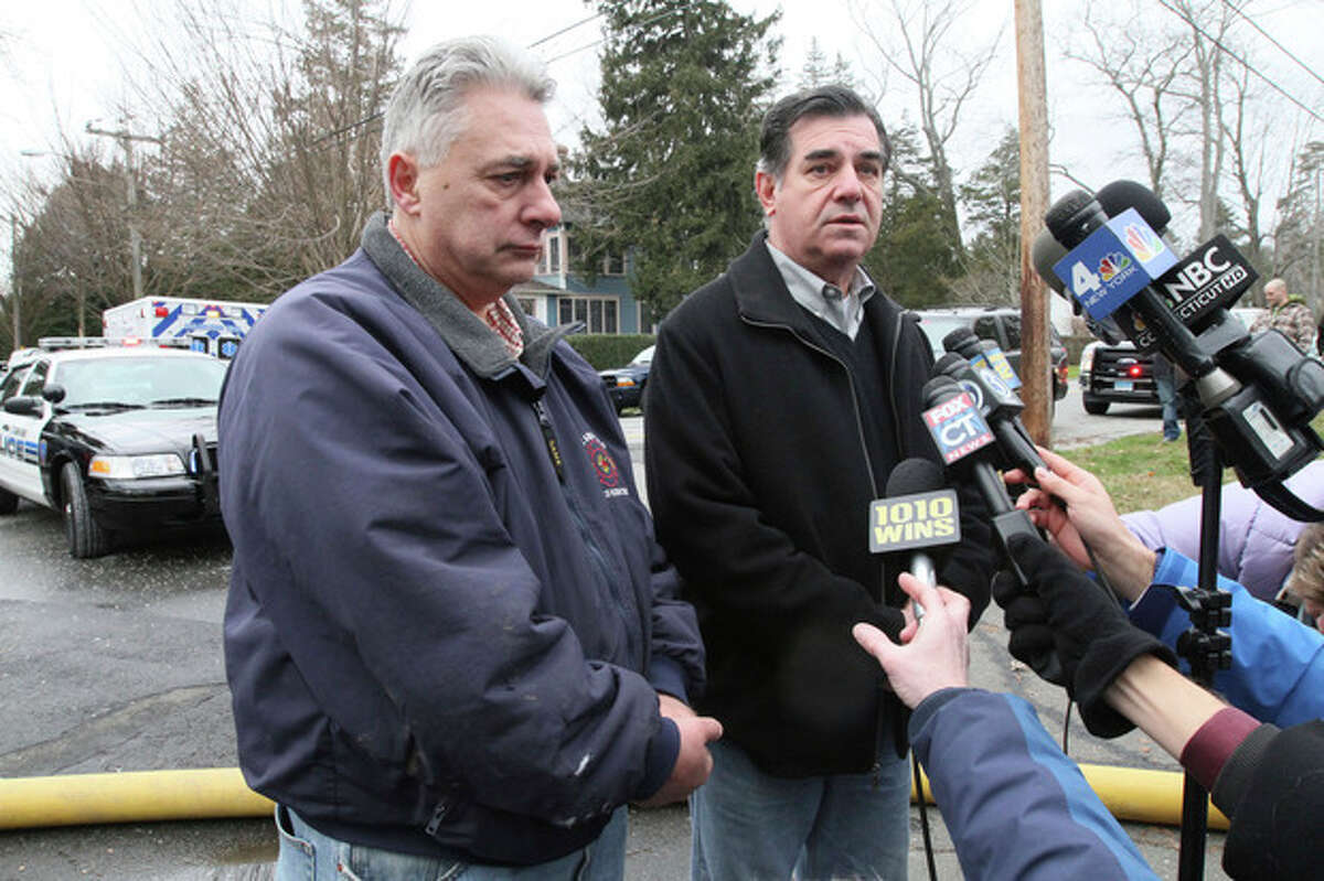 Antonio Conte, Stamford, Conn. Fire Chief, left, stands by as he and Michael Pavia, mayor of Stamford, Conn., hold a news conference regarding the early morning fire which left five people dead at a home down the street in Stamford, Conn. Sunday Dec. 25, 2011. (AP Photo/Tina Fineberg)
