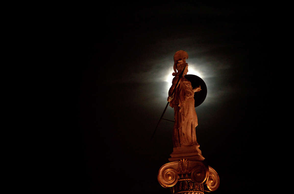A statue of ancient Greek Goddess Athena is highlighted by the moon, in the center of the Greek capital after elections on Sunday, May 6, 2012. Voters in crisis-hit Greece punished parties that have dominated politics for decades, with parties opposed to the country's bailout agreements gaining ground. (AP Photo/Kostas Tsironis)